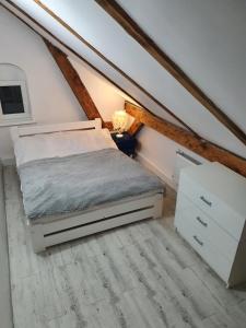 a bedroom with a bed and a dresser in a attic at Niebiańska Przystań in Ustka