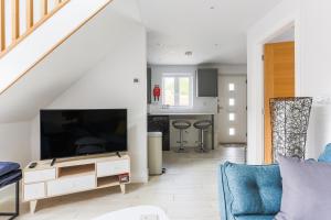 a living room with a tv and a blue couch at Little Cedars House in Truro