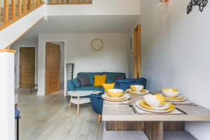 ein Wohnzimmer mit einem Tisch und einem blauen Sofa in der Unterkunft Little Cedars House in Truro