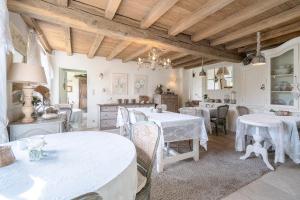 una sala da pranzo con tavoli e sedie bianchi di Guesthouse B&B De Loverlij a Jabbeke