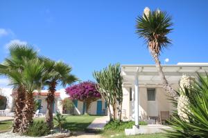 ein Haus mit Palmen davor in der Unterkunft Antichi Mulini in Favignana