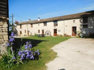 an old stone building with purple flowers in front of it at Chatenet self catering stone House for 2 South West France in Limalonges