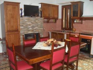 cocina con mesa de madera y sillas rojas en Il Covo dei Piccioni, en Castelfidardo