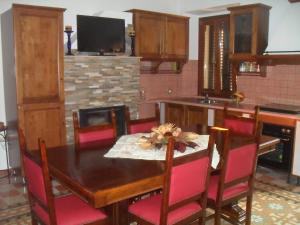 a kitchen with a wooden table with red chairs at Il Covo dei Piccioni in Castelfidardo