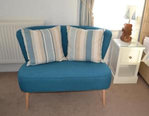 a blue chair with two pillows on top of it at Tregony Guest House in St Ives