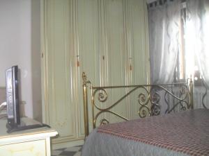 una camera con letto e televisore su un comò di Il Covo dei Piccioni a Castelfidardo