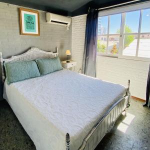 Un dormitorio con una cama grande y una ventana en VIAJERO Posada & Hostel Punta del este, en Punta del Este