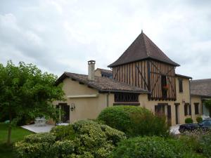 a large house with a tower and a turret at Les Sureaux in Le Pizou