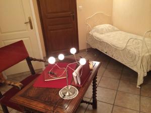Habitación con cama y mesa con lámpara. en Les Sureaux, en Le Pizou
