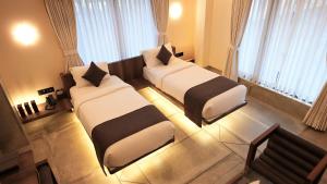 苏拉特De Glance Hotel, Near Surat Railway Station的带窗户的酒店客房内的两张床 更多37张照片