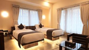 苏拉特De Glance Hotel, Near Surat Railway Station的带窗户的酒店客房内的两张床