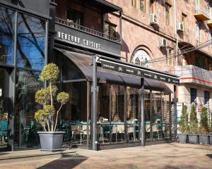 a restaurant with an awning on a city street at Saryan Hotel Yerevan in Yerevan