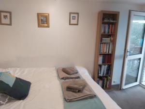 a bedroom with a bed with two towels on it at Garden Apartment in Newton Abbot