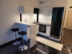 a kitchen with a counter and two stools in it at Apartamenty Potulicka Centrum in Szczecin +31 photos