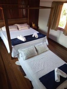 a bedroom with two beds with towels on them at Pousada Chalé na Roça Penedo in Penedo