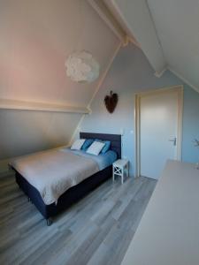 a bedroom with a bed and a white ceiling at Siësta in Westkapelle