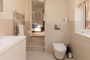 Un baño blanco con inodoro y lavabo. en Central Hidden Gem, en Henley on Thames 25 fotos más