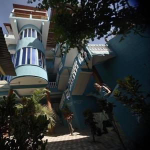a blue building with a spiral staircase in front of it at Mandala’s Hostal in San Pedro La Laguna