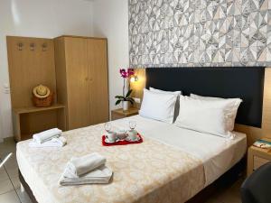 a hotel room with a bed with two glasses and towels at Caravel Hotel Apartments in Ixia