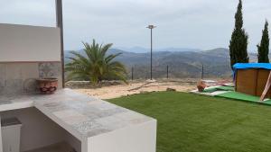 AlmogíaにあるCasa Cuatro Vientos - Barranco Del Solの山の景色を望む緑の芝生のある裏庭