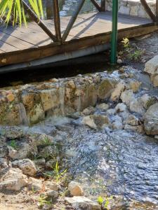 a stream of water next to a wooden bridge at Quinta Lagus Resort - Casa de Campo in Palmela