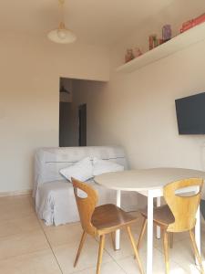 sala de estar con mesa, sillas y sofá en Joli Appartement, terrasse plein sud, en Roquebrun
