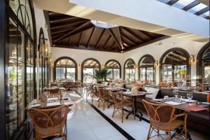 un restaurant avec des tables, des chaises et des fenêtres dans l'établissement Hotel LIVVO Volcán Lanzarote, à Playa Blanca