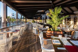 a restaurant with white tables and chairs and a view at Hotel LIVVO Volcán Lanzarote in Playa Blanca