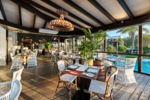 een eetkamer met tafels en stoelen en een kroonluchter bij Hotel LIVVO Volcán Lanzarote in Playa Blanca