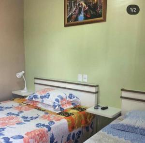 a bedroom with a bed and a table and a picture on the wall at Pousada Nativa Lages in Lages