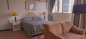 a hotel room with a bed and a chair at Jandaia Hotel Campo Grande in Campo Grande