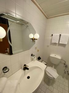 La salle de bains blanche est pourvue d'un lavabo et de toilettes. dans l'établissement Apartment Haus C Top 33 -by Four Seasons Apartments, à Kaprun