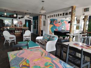 a living room with a table and chairs and a piano at PASTORA Suites & Hostel - Punta del este in Punta del Este