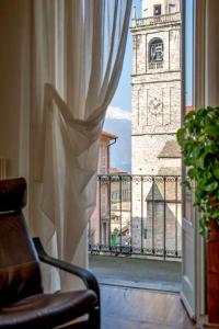 een raam met uitzicht op een klokkentoren bij San Giacomo Central Apartment in Bellagio