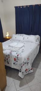 2 camas con sábanas blancas y flores rojas. en Nuestro Lugar en Luján de Cuyo, cercano a Bodegas y Viñedos en Luján de Cuyo