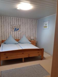 a bedroom with a wooden bed with blue pillows at Ferienwohnungen-im-Koog-2 in Wesselburenerkoog