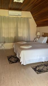 a bedroom with two beds and a window at Pousada Villa Di Carpi in Monte Sião