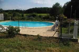 a large swimming pool with a fence around it at Chambres d'Hotes du Maine in Lalinde