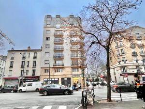 a building on a busy city street with cars at CLICHY QUARTIER VICTOR HUGO - Superbe appartement entièrement rénové in Clichy