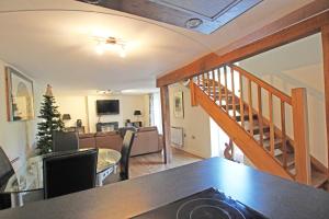 a living room with a staircase and a living room at Grooms Cottage in Kent