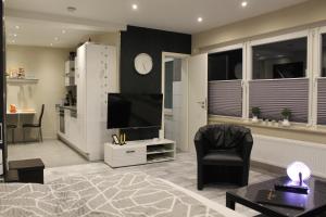 a living room with a television and a chair at Ferienwohnung Kleine Auszeit in Coesfeld in Coesfeld