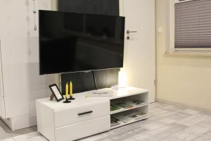 a white entertainment center with a flat screen tv on a wall at Ferienwohnung Kleine Auszeit in Coesfeld in Coesfeld