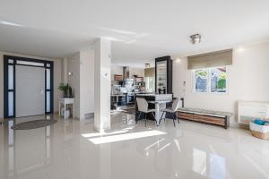 a white living room with a table and chairs at Luxusvilla Sol y Mar mit grandiosem Meerblick in Adeje