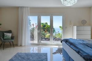 a bedroom with a bed and a large window at Luxusvilla Sol y Mar mit grandiosem Meerblick in Adeje +96 photos