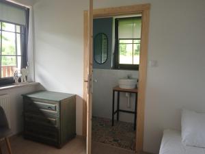 une salle de bain avec un lit, un lavabo et un miroir dans l'établissement Powidok, à Wetlina 95 autres photos