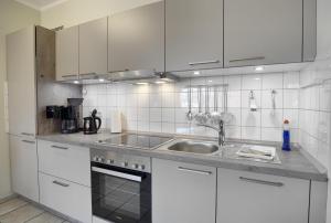 a kitchen with white cabinets and a sink at Wohnung Central FW 4 mit Balkon in Zingst