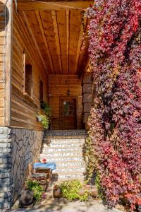 un porche de una casa con una mesa y flores en Penzion Zbojník, en Terchová