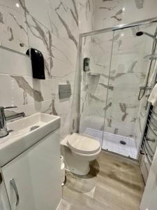 a bathroom with a shower and a toilet and a sink at Entire house, Only 25 mins to London, FREE Cancellation 48hrs prior to arrival in West Byfleet