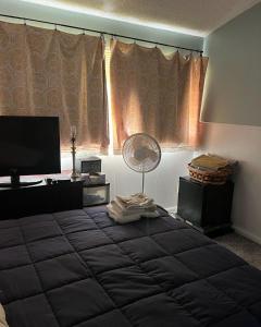 a bedroom with a large bed in front of a window at COMFY COZY ROOM ON QUIET CUL-DE-SAC in Los Angeles