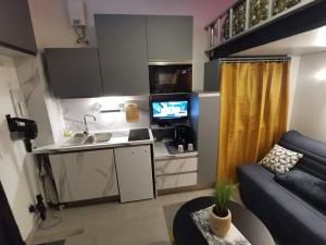 eine kleine Küche und ein Wohnzimmer mit einem Sofa in der Unterkunft Studette "La Fourmi" proche centre et plage in Beaulieu-sur-Mer